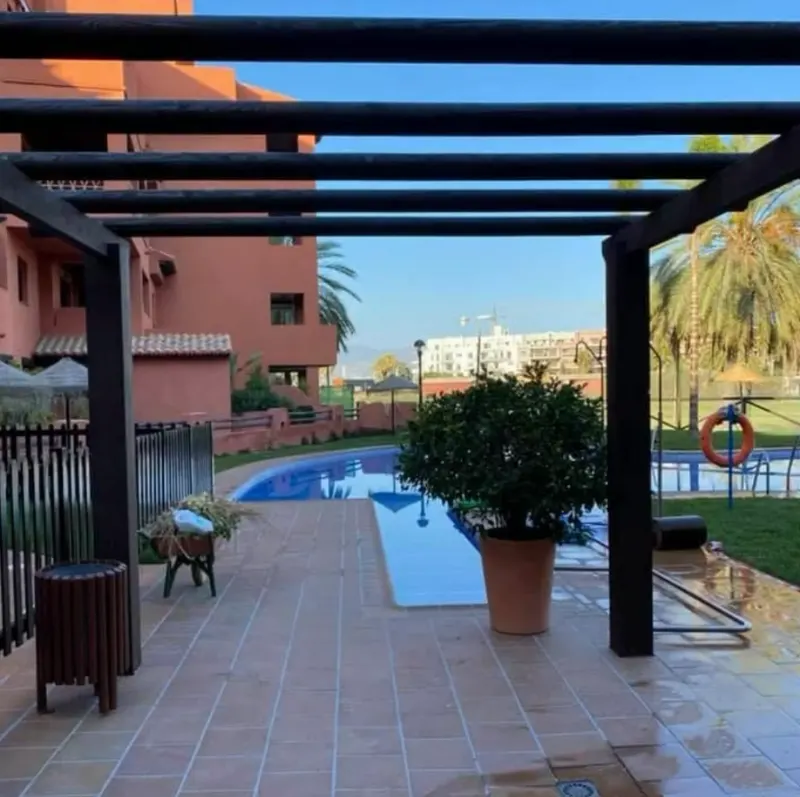 Pérgola de madera junto a la piscina